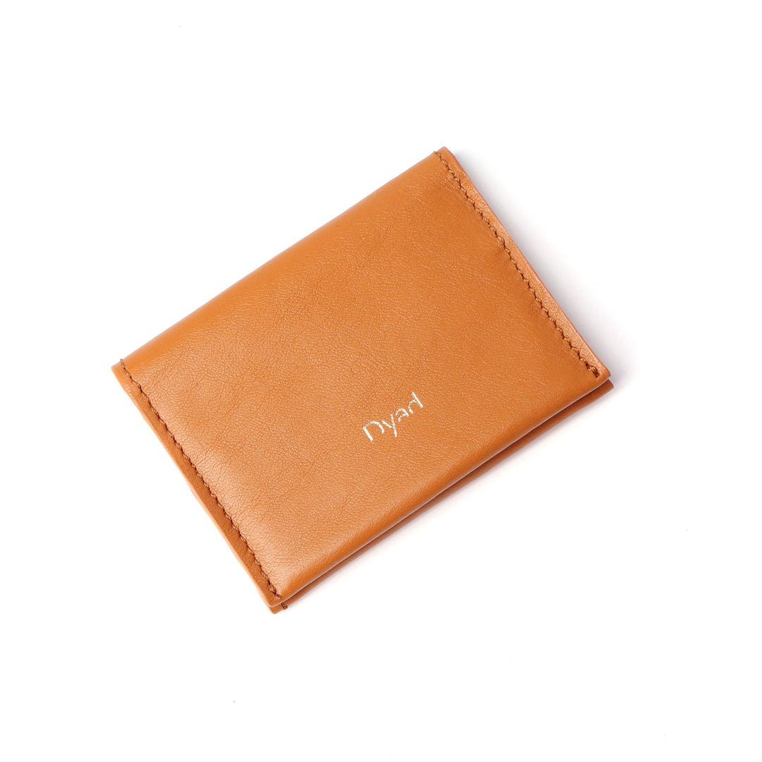 Project Dyad Wave Cardholder in Tan, closed with gold Dyad logo
