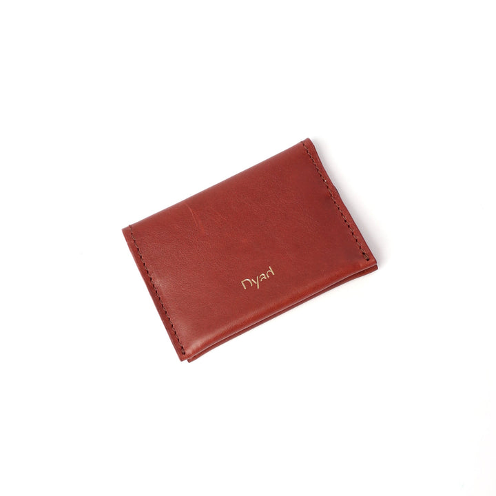 Project Dyad Wave Cardholder in Teak, closed with gold Dyad logo