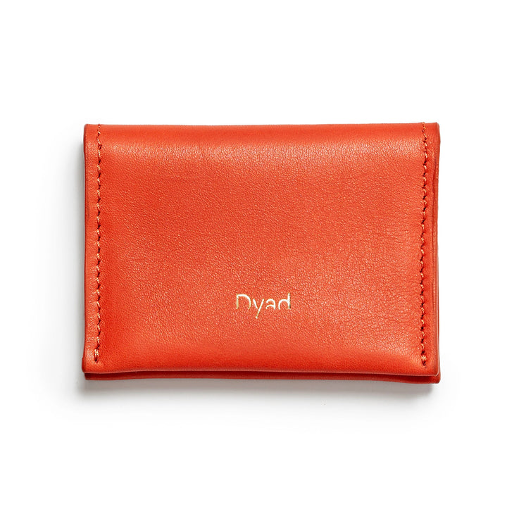 Project Dyad Wave Cardholder in Lobster Red, closed with gold Dyad logo