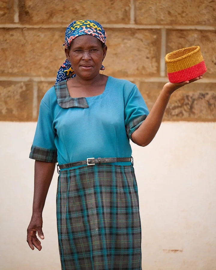 HELA by The Basket Room — artisan holding a gold and red basket; size not specified