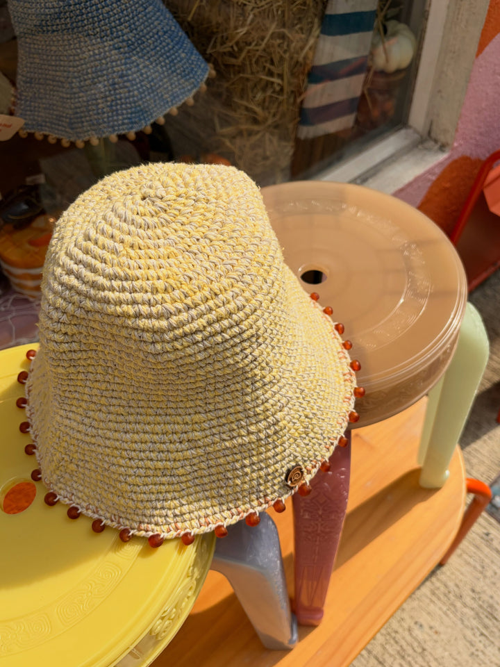 Top view of the Earth Age × Goosebump Butter Yellow crochet hat with orange glass beads