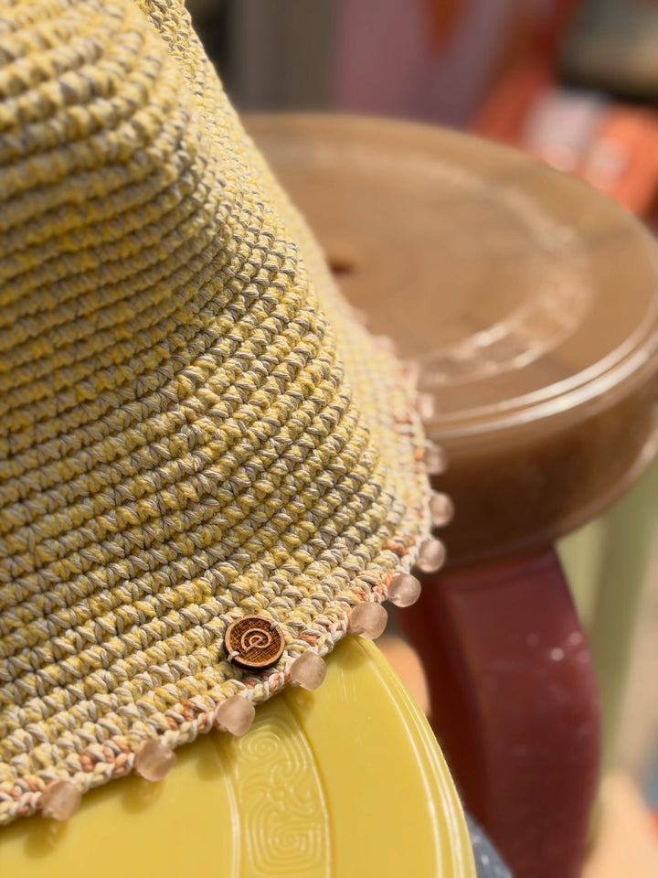 Close-up of pink glass beads and orange checker detail on the Earth Age × Goosebump Butter Yellow crochet hat