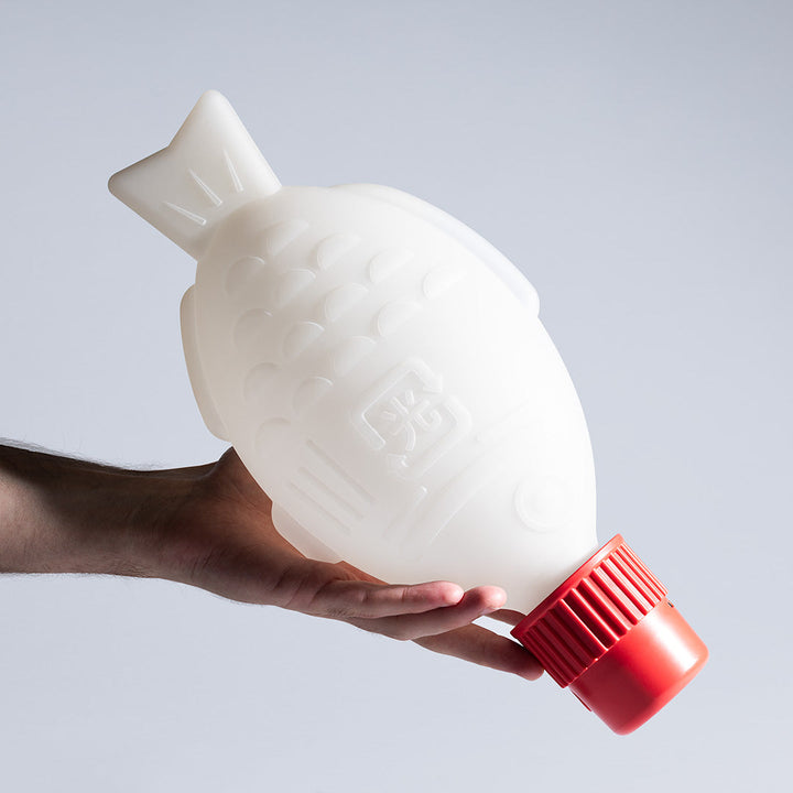 Heliograf Light Soy Portable unlit fish-shaped lamp held in a hand