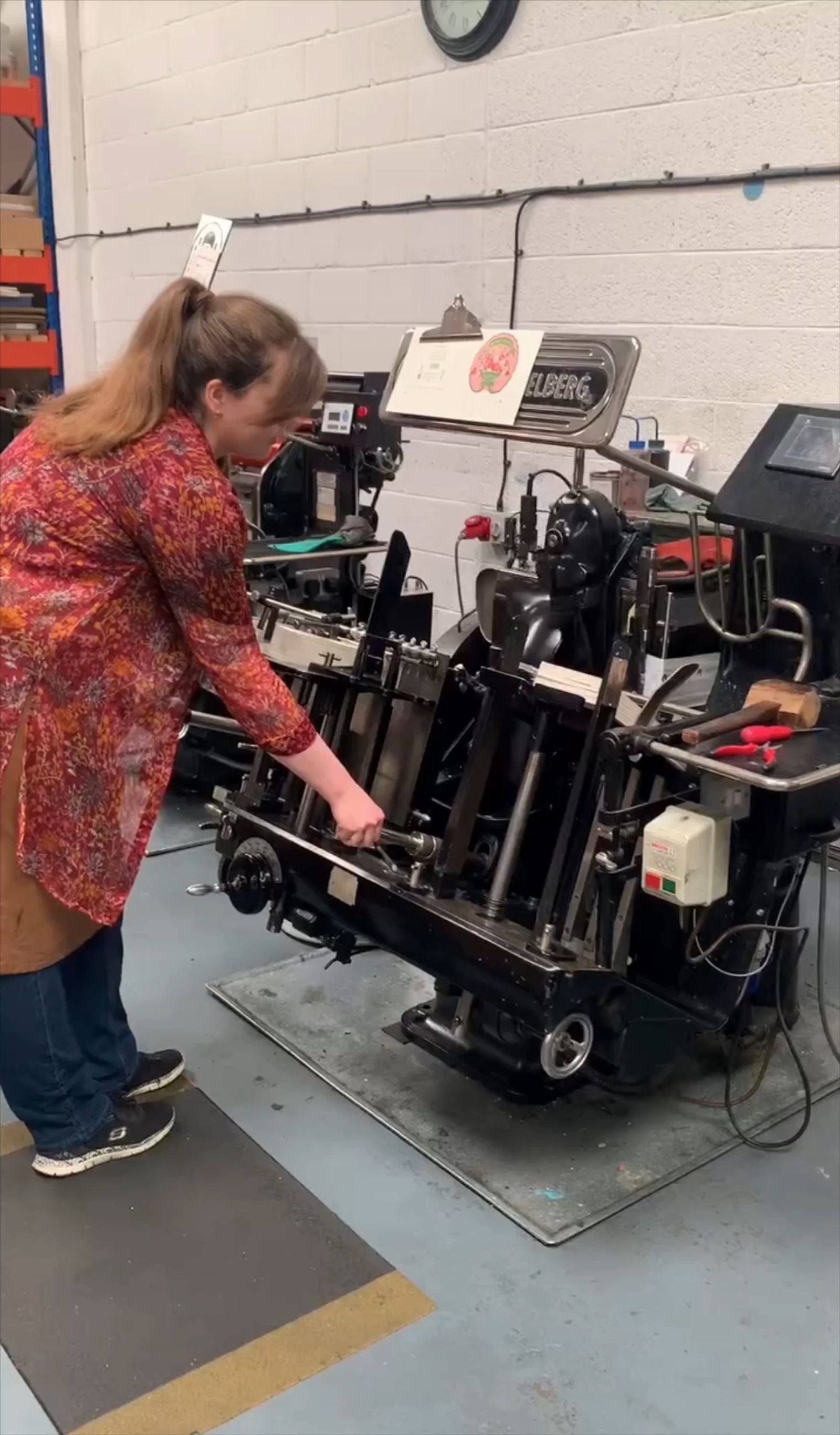 Print studio team member operating a letterpress machine